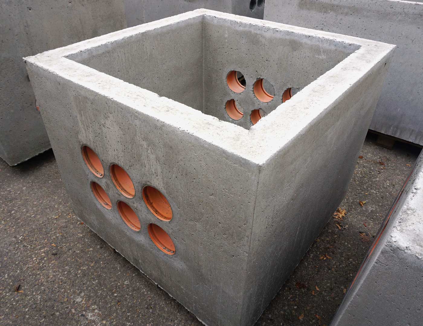 Beton Kabelaufbauschacht mit runden Öffnungen an den Seiten, quadratisch geformt.