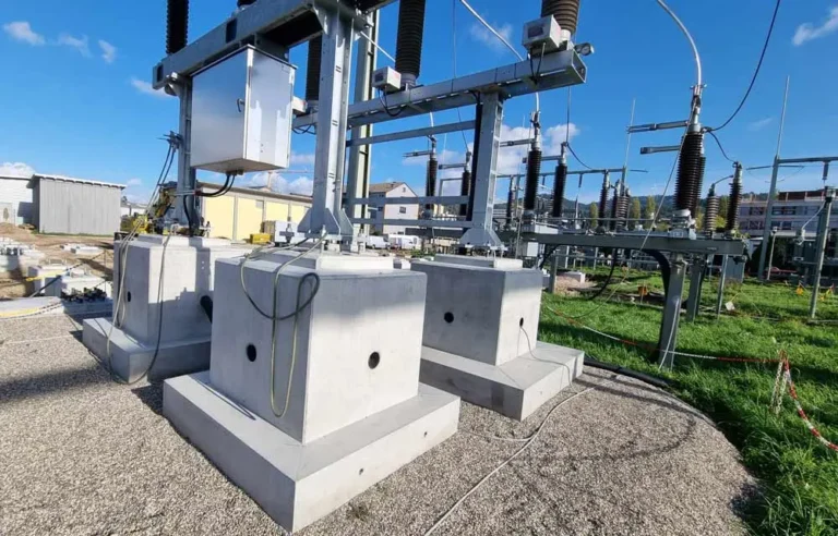 Betonfundamente und elektrische Ausrüstung in einem Umspannwerk auf einem Gelände.