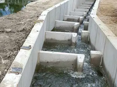 Betonfischtreppe mit Wasserfluss und mehreren Stufen in einem geraden Verlauf.