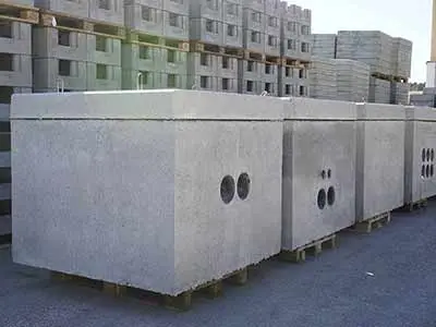 Reihe von Beton Kabelschächten mit runden Öffnungen in einer Lagerumgebung.