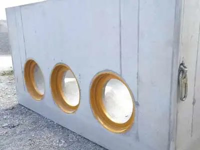 Betonkanalschacht mit drei runden Fenstern in orange umrandet.
