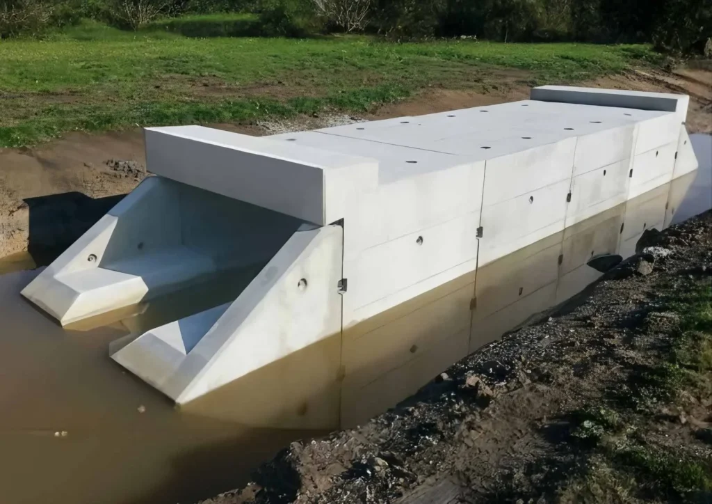 Betonrahmenprofil, das in einem Gewässer installiert ist, mit zwei Auslässen an den Seiten.